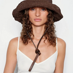 KABE SHOP INC brown crochet hat bag with a leather chin strap worn by a woman with curly hair