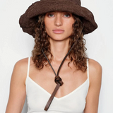 KABE SHOP INC brown crochet hat bag with a leather chin strap worn by a woman with curly hair