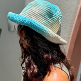 KABE SHOP INC Pora crochet hat in blue and white tie-dye worn by a woman with long wavy hair in profile view