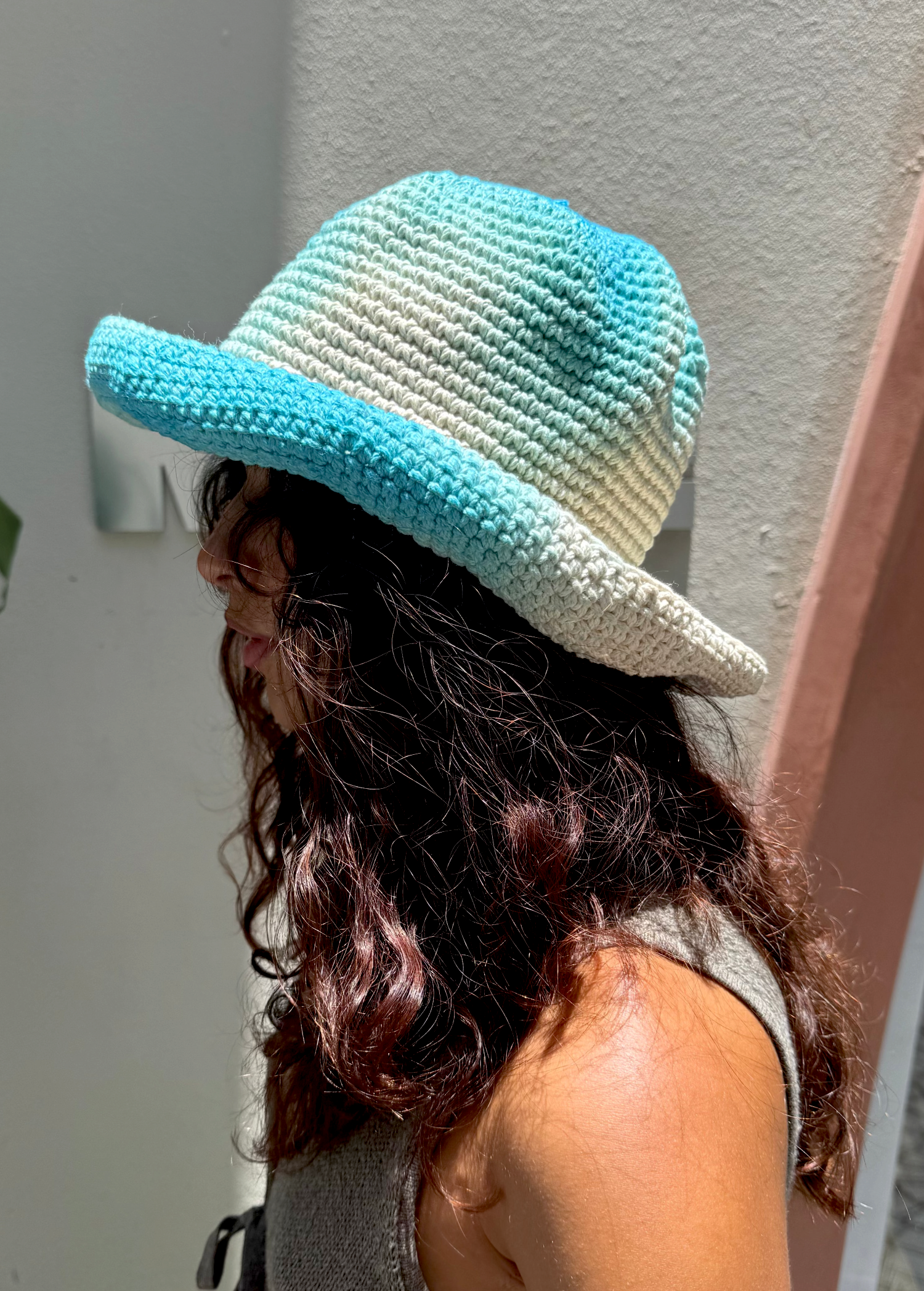 KABE SHOP INC Pora crochet hat in blue and white tie-dye worn by a woman with long wavy hair in profile view