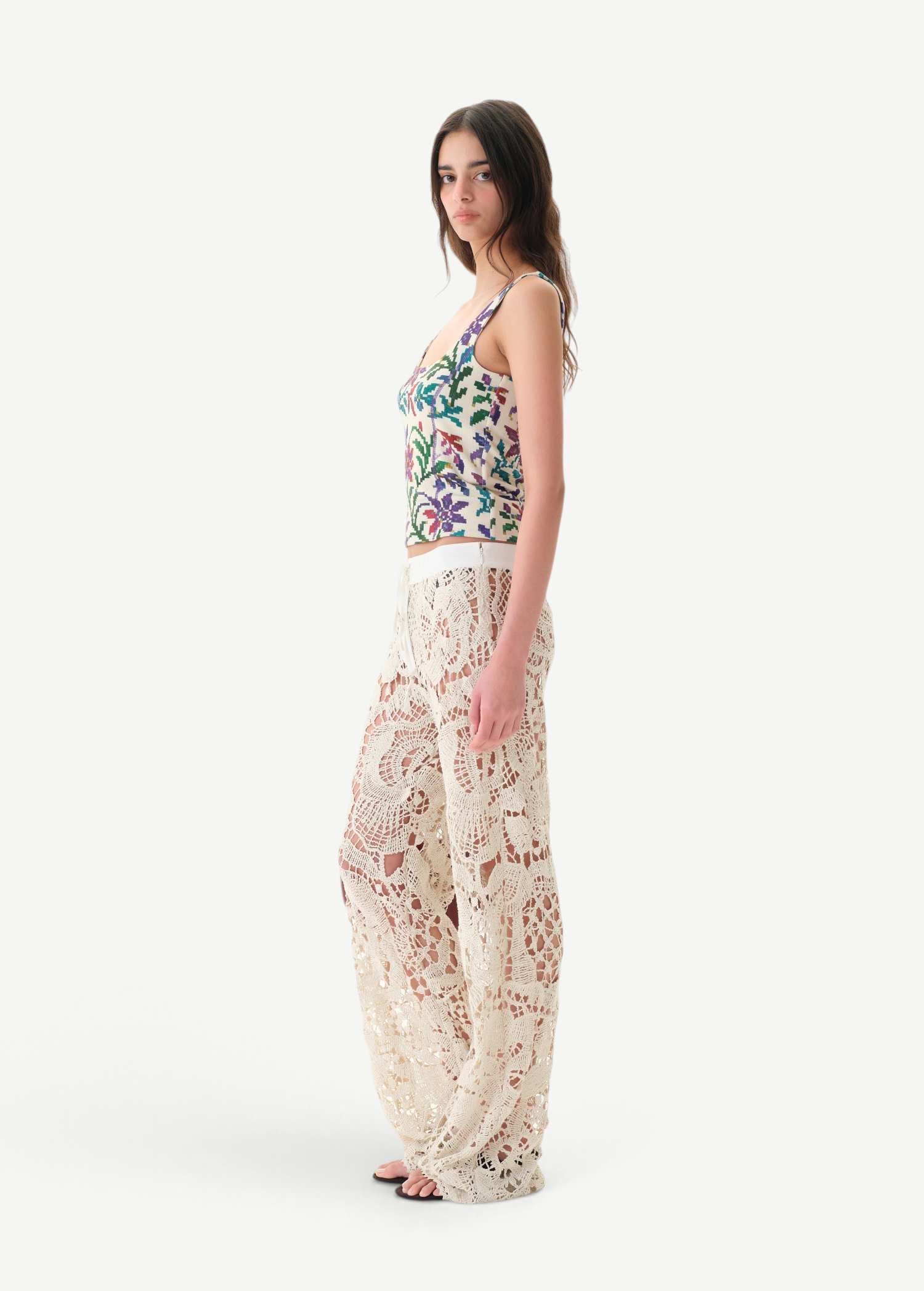 Model wearing KABE SHOP INC Cali Top with floral pattern and wide straps paired with cream lace trousers