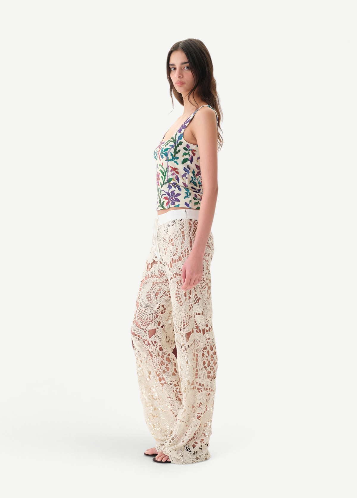 Model wearing KABE SHOP INC Cali Top with floral pattern and wide straps paired with cream lace trousers