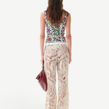 KABE SHOP INC Cali Top featuring a colorful floral print, worn with cream crochet lace trousers and a maroon bag.