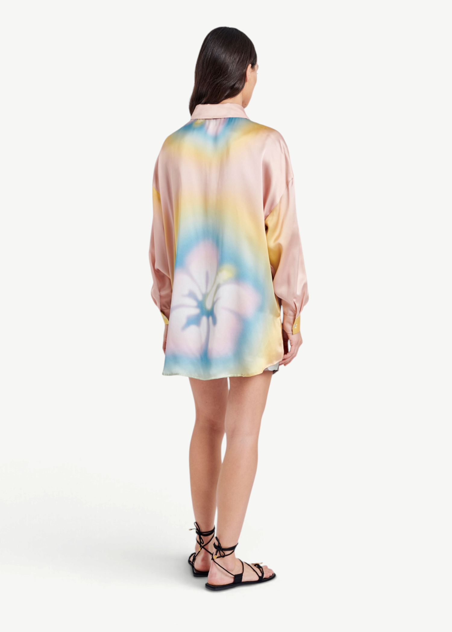 Model wearing a KABE SHOP INC Hibiscus Top in multi-colored silk with a floral print, back view.