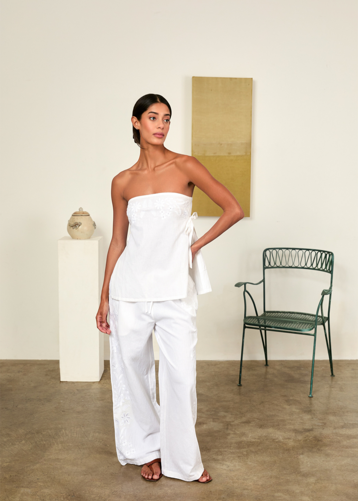 Model wearing KABE SHOP INC white strapless Sebastian Top with floral embroidery and side tie detail