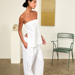 Model wearing KABE SHOP INC white strapless Sebastian Top with floral embroidery and side tie details