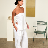 Model wearing KABE SHOP INC white strapless Sebastian Top with floral embroidery and side tie details