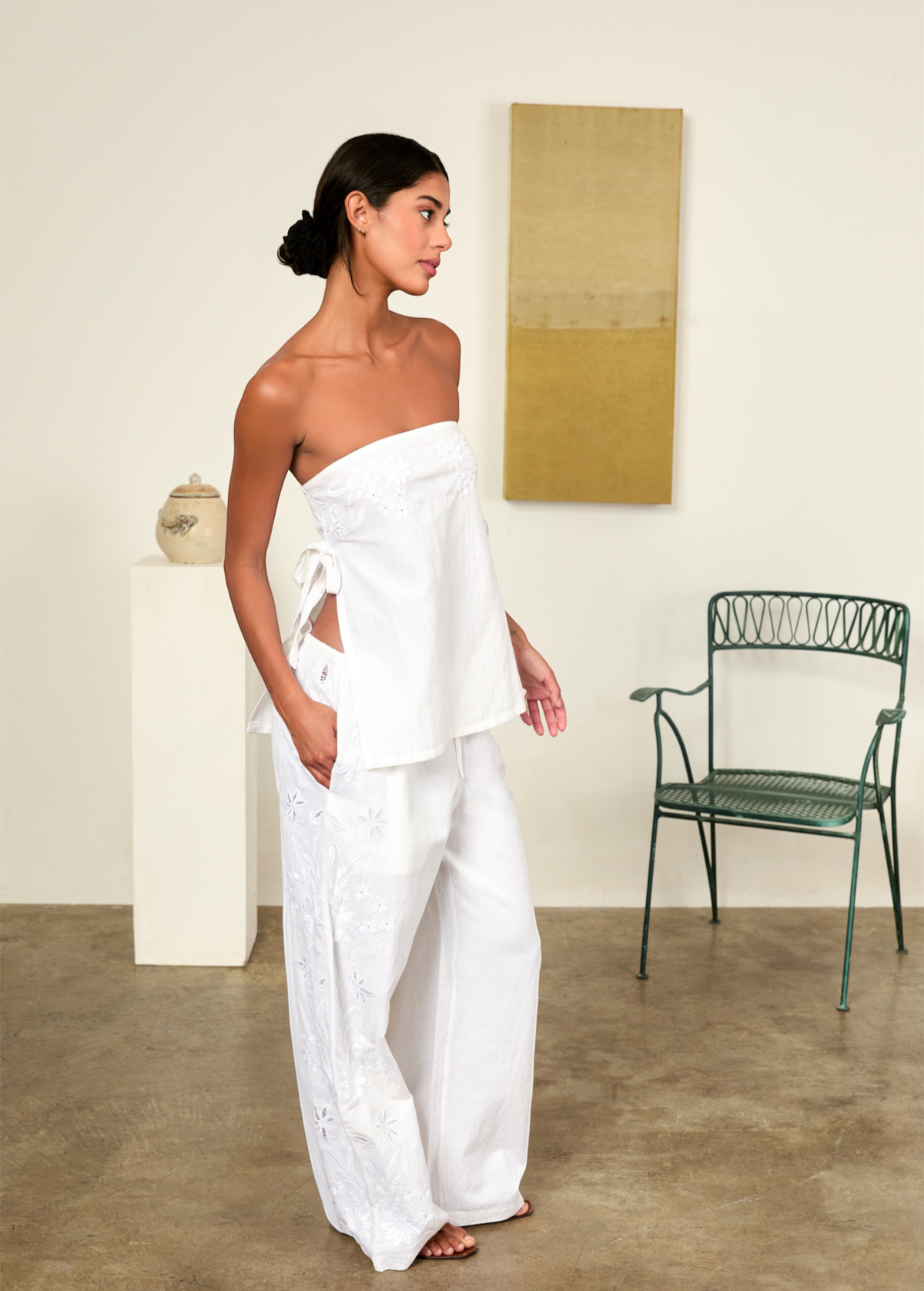 Model wearing KABE SHOP INC white strapless Sebastian Top with floral embroidery and side tie details