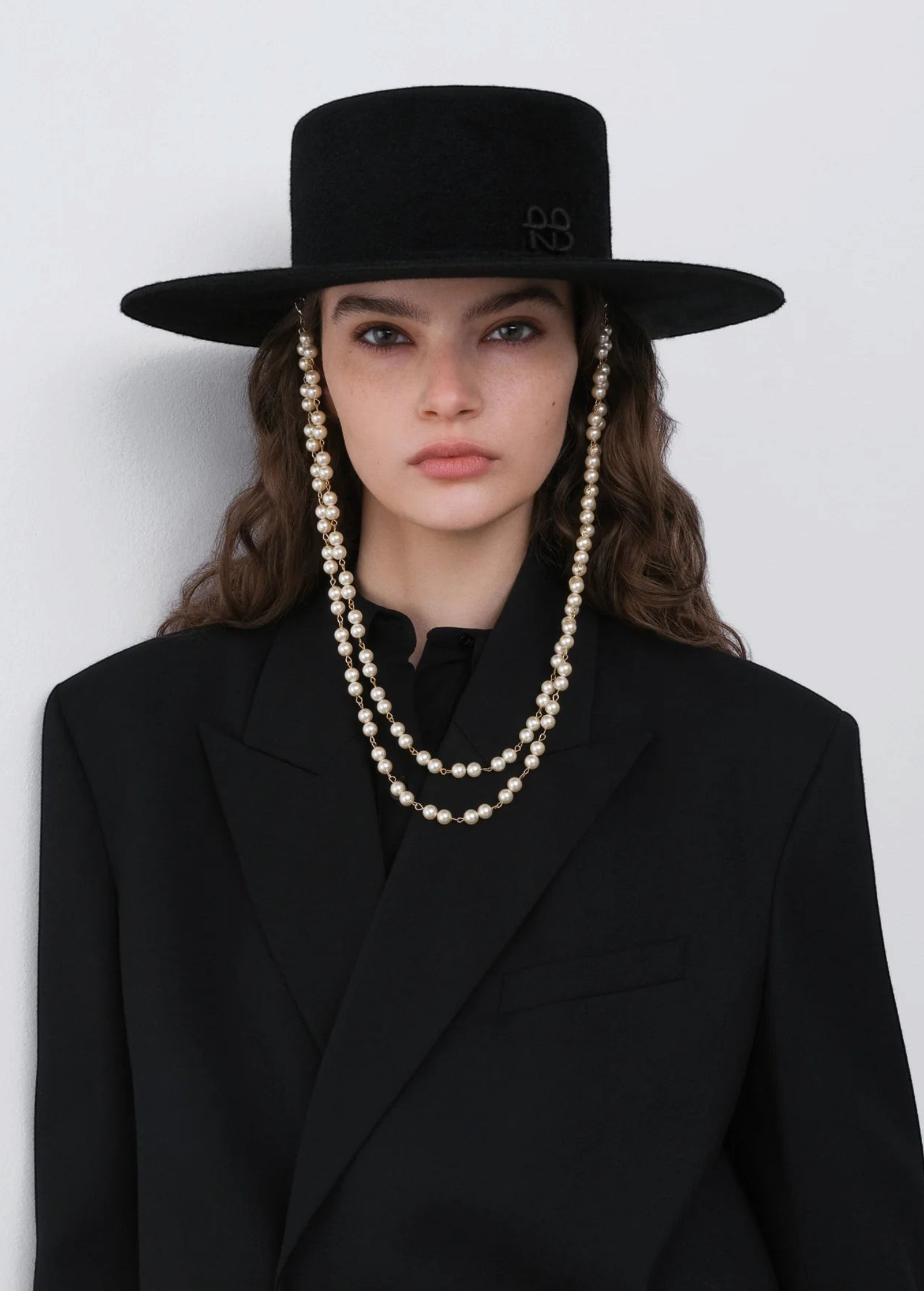 KABE SHOP INC black canotier hat with double pearl chain strap worn by a model in a black blazer