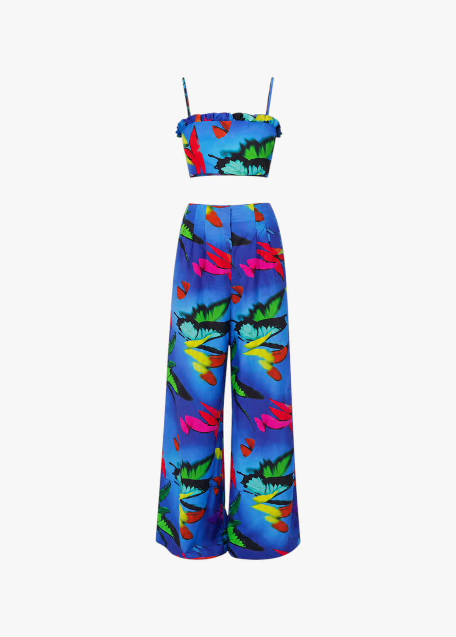 The Alma Set is a colorful tropical print two-piece linen ensemble featuring a cropped spaghetti strap top and wide-leg high-waisted pants. Perfect for versatile styling, this standout outfit is beautifully showcased against a plain white background.