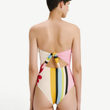 Model wearing KABE SHOP INC Ulla one piece swimsuit with a multi-colored striped pattern and back tie detail.