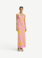 Model wearing a KABE SHOP INC Daphne strapless pink maxi dress with yellow floral print and ruched side detailing