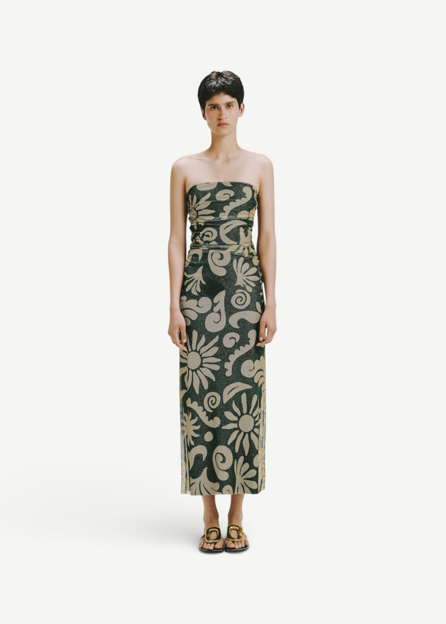 Model wearing KABE SHOP INC Daphne dress, a strapless midi length piece with a dark green and beige floral pattern.