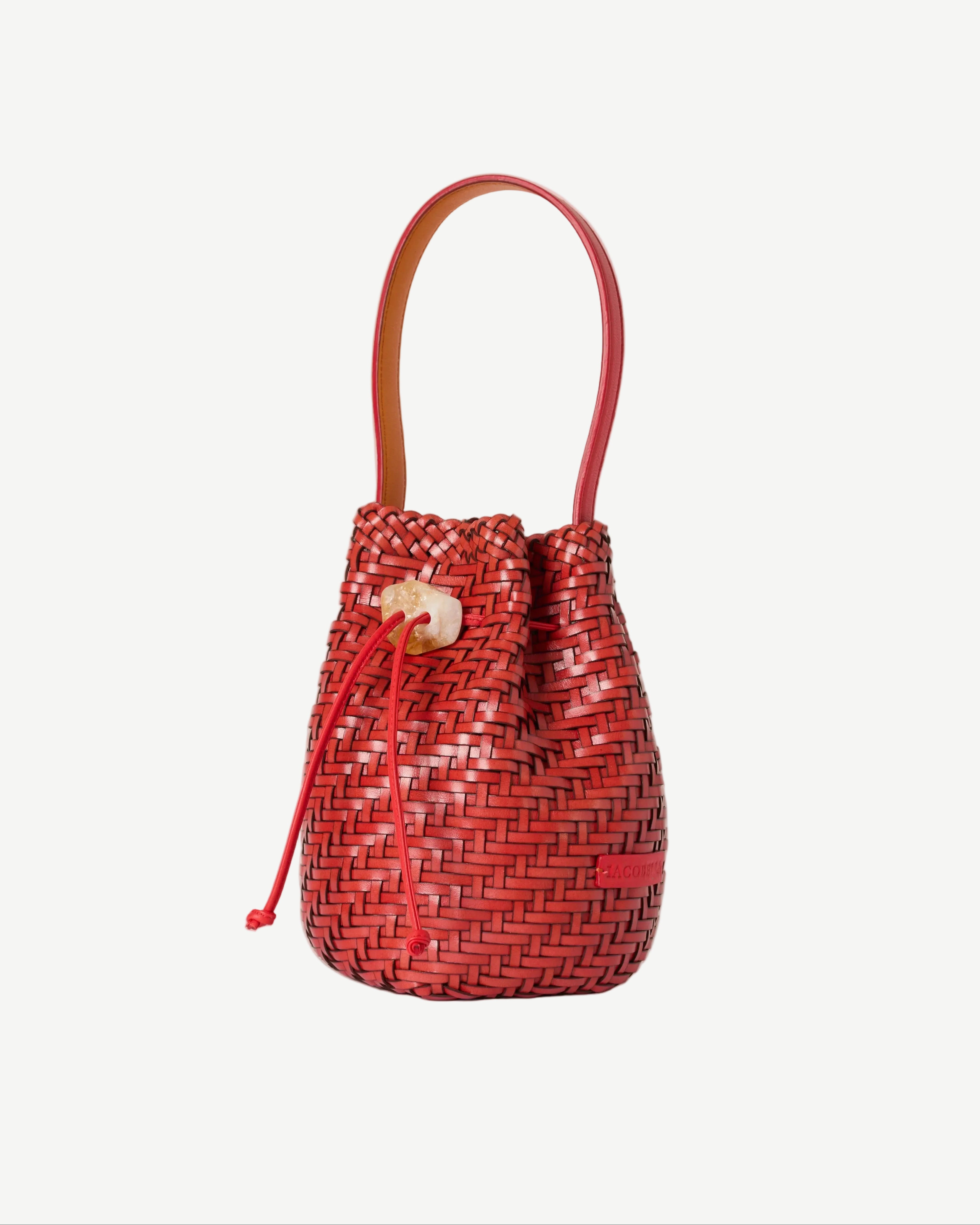 Red woven bucket bag with a handle on a white background
