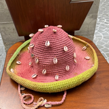 KABE SHOP INC Wika crochet hat in pink and green tie-dye featuring decorative white seashells on a wooden chair