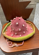 KABE SHOP INC Wika crochet hat in pink and green tie-dye featuring decorative white seashells on a wooden chair