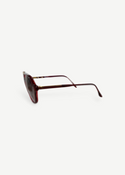KABE SHOP INC Christopher D sunglasses featuring a deep red translucent frame and gold metal accents, side view.