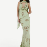 A person wears the sage green, floor-length georgette Diosa Skirt with a cowl neckline, brown floral print, and an asymmetric hem.