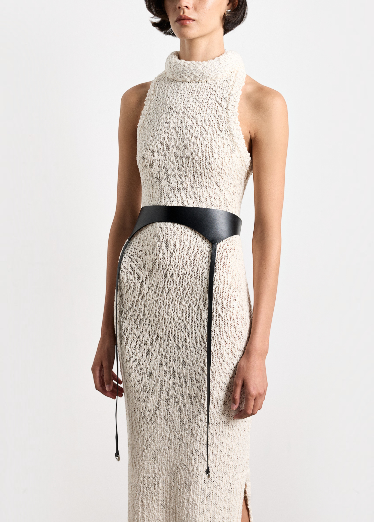 Model wearing KABE SHOP INC Laisse black Italian calfskin garter belt over a textured cream knit sleeveless dress