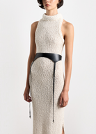 Model wearing KABE SHOP INC Laisse black Italian calfskin garter belt over a textured cream knit sleeveless dress