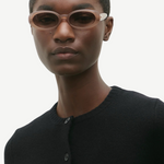 KABE SHOP INC Valentina oval sunglasses in translucent blush acetate worn by a model in a black cardigan