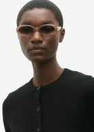 KABE SHOP INC Valentina oval sunglasses in translucent blush acetate worn by a model in a black cardigan