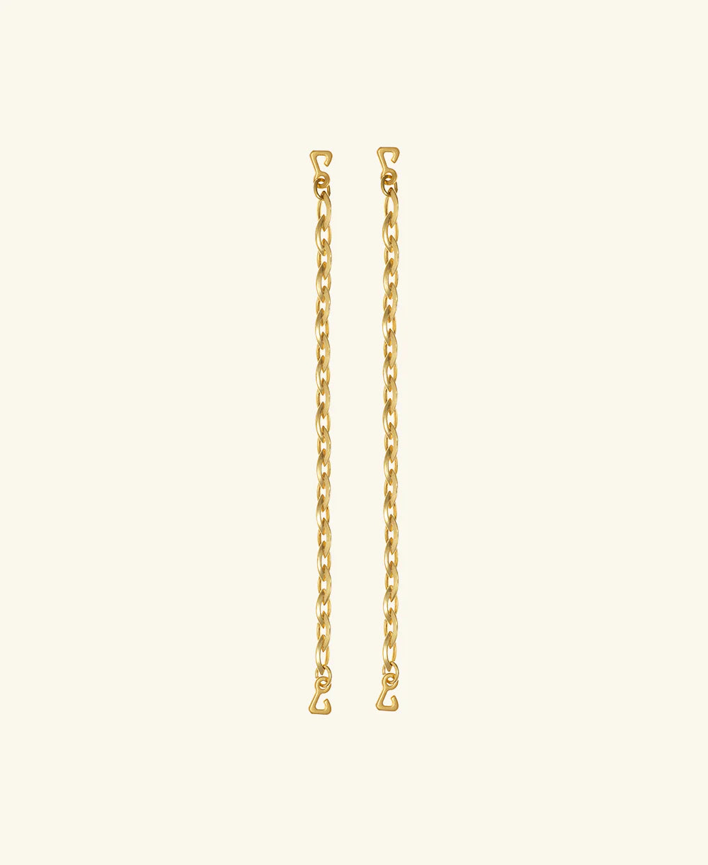 Two pieces from the Lola Swimwear collection, featuring gold chain earrings with small heart-shaped hooks at each end reminiscent of delicate jewelry straps, are displayed vertically against a plain, light beige background.