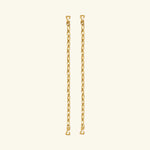 Two pieces from the Lola Swimwear collection, featuring gold chain earrings with small heart-shaped hooks at each end reminiscent of delicate jewelry straps, are displayed vertically against a plain, light beige background.