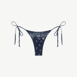 Praia Bottom in navy blue with a white paisley bandana print, crafted from eco-terry fabric, features a low-rise silhouette and adjustable side ties, shown on a white background.