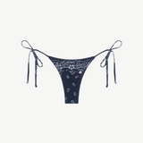 Praia Bottom in navy blue with a white paisley bandana print, crafted from eco-terry fabric, features a low-rise silhouette and adjustable side ties, shown on a white background.