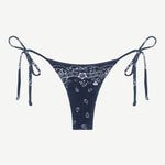Praia Bottom in navy blue with a white paisley bandana print, crafted from eco-terry fabric, features a low-rise silhouette and adjustable side ties, shown on a white background.