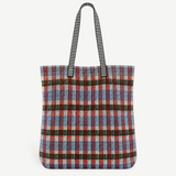 KABE SHOP INC Kanpur bag featuring a vibrant multi-colored plaid woven textile pattern and black striped handles.
