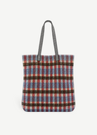 KABE SHOP INC Kanpur bag featuring a vibrant multi-colored plaid woven textile pattern and black striped handles.