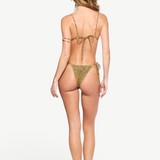 A woman stands with her back to the camera against a white background, wearing the Equator Top—a leopard print recycled nylon triangle bikini top—and black sandals. Her hair is loose and wavy.