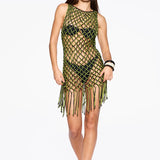 A woman poses against a plain white background in the Castaway Dress—a neon green and black macrame tunic style worn over a black bikini. She completes the look with sunglasses, sandals, and a confident hand on her hip.