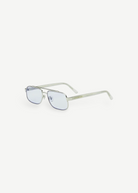 Evangeline eyeglasses featuring a sleek stainless steel silver frame, thin rectangular blue-tinted lenses with UV protection, and clear, slightly curved earpieces, displayed on a white background.