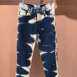 KABE SHOP INC tie dye denim jeans with a dark blue and bleached white abstract pattern hanging on a clothes hanger.