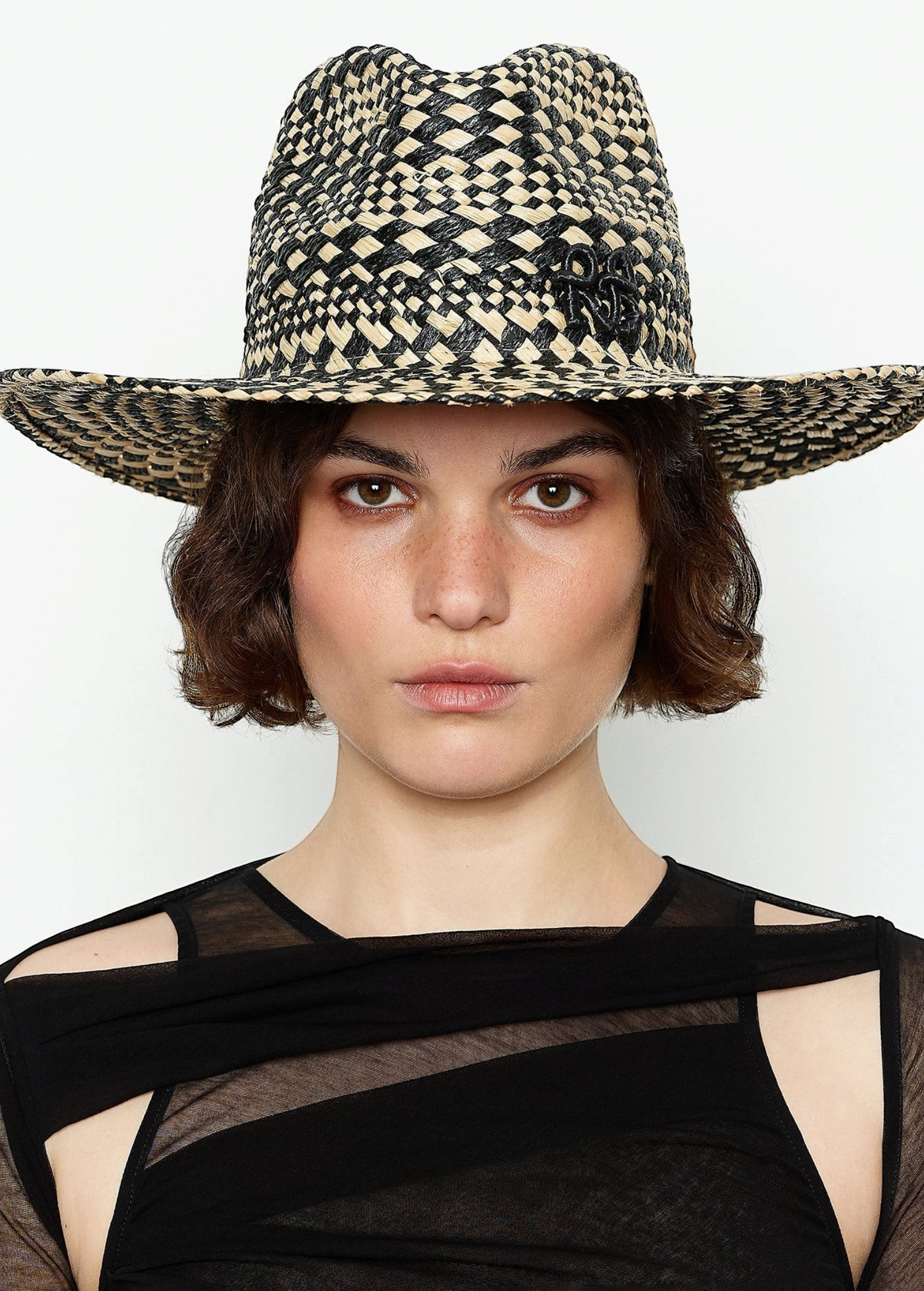 KABE SHOP INC rhomboidal pattern straw fedora hat worn by a woman with short brown hair against a white background