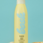 KABE SHOP INC non-aerosol SPF 30 sunscreen spray in a yellow bottle on sand with a seashell against a blue background