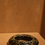 KABE SHOP INC wood and resin bangle featuring a black and tan circular pattern in a sculptural, modern design.