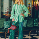 Model wearing KABE SHOP INC Pia Poplin Pants in a vibrant green and blue stripe with a matching button-down shirt.