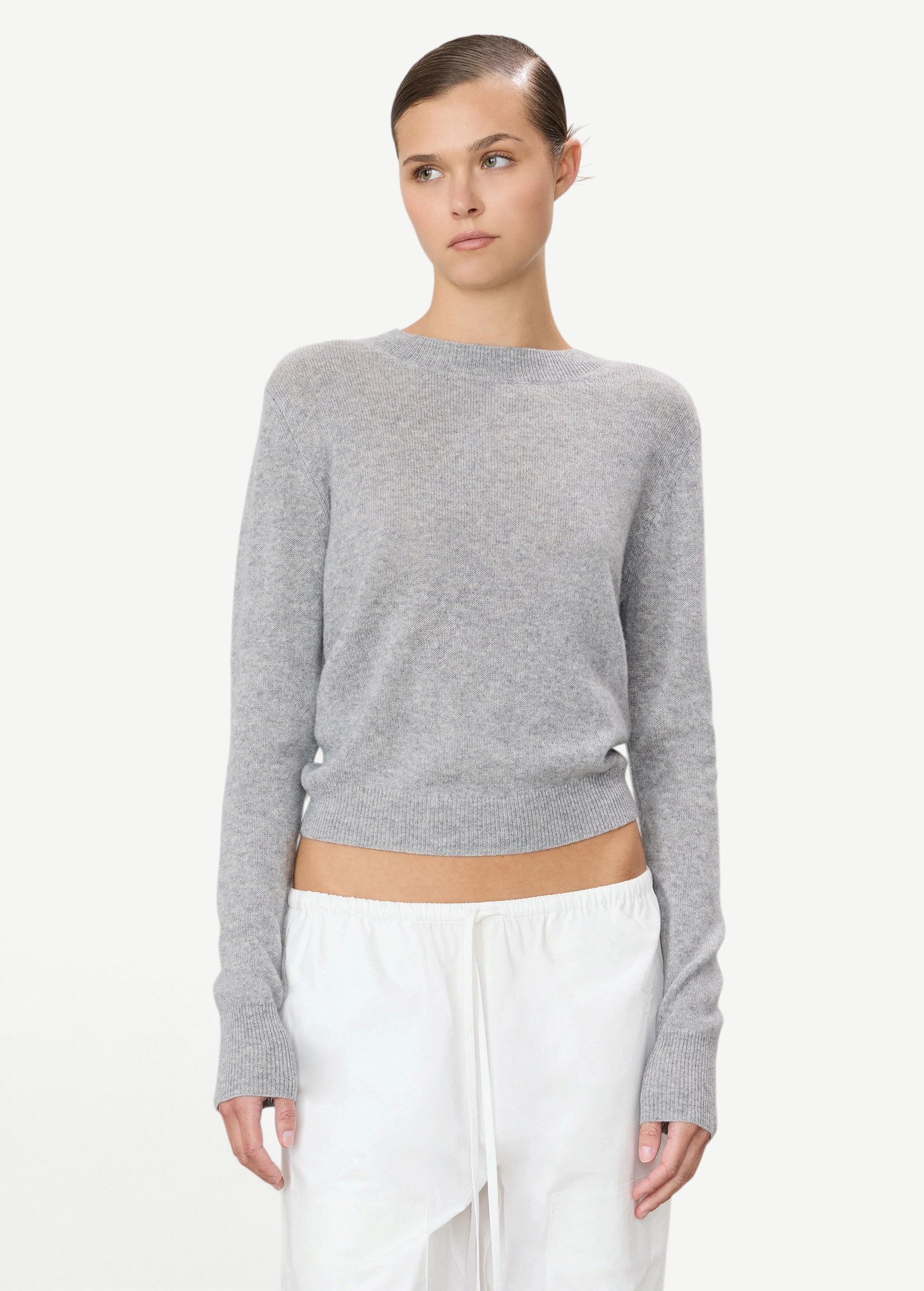 Model wearing a grey KABE SHOP INC Francis cashmere sweater with a slim fit and cropped hem on a white background