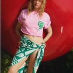 Model wearing a KABE SHOP INC Grass Seeds Pareo with a green geometric print, styled as a beach cover-up.