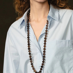 KABE SHOP INC Lark Drip Necklace featuring faceted smoky quartz beads and a gold claw pendant with peridot drops.