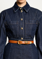KABE SHOP INC Hollyhock belt in tan Italian calfskin leather with 24K gold hardware worn over a dark denim dress