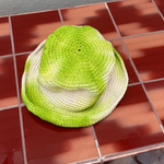 KABE SHOP INC handmade crochet bucket hat with a vibrant green and white tie-dye pattern on a red tiled surface