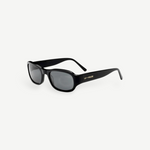 The Jordyn sunglasses are black, rectangular-shaped with thick frames and dark lenses. LU GOLDIE’s name appears in gold lettering on the arms. Displayed against a plain white background, these standout festival sunglasses provide reliable UV protection for sunny days outdoors.