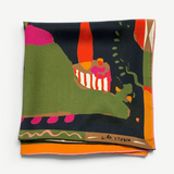 A folded Labyrinth of Horta Scarf featuring an abstract, colorful landscape print with hand-drawn labyrinth shapes in green, black, orange, and pink.