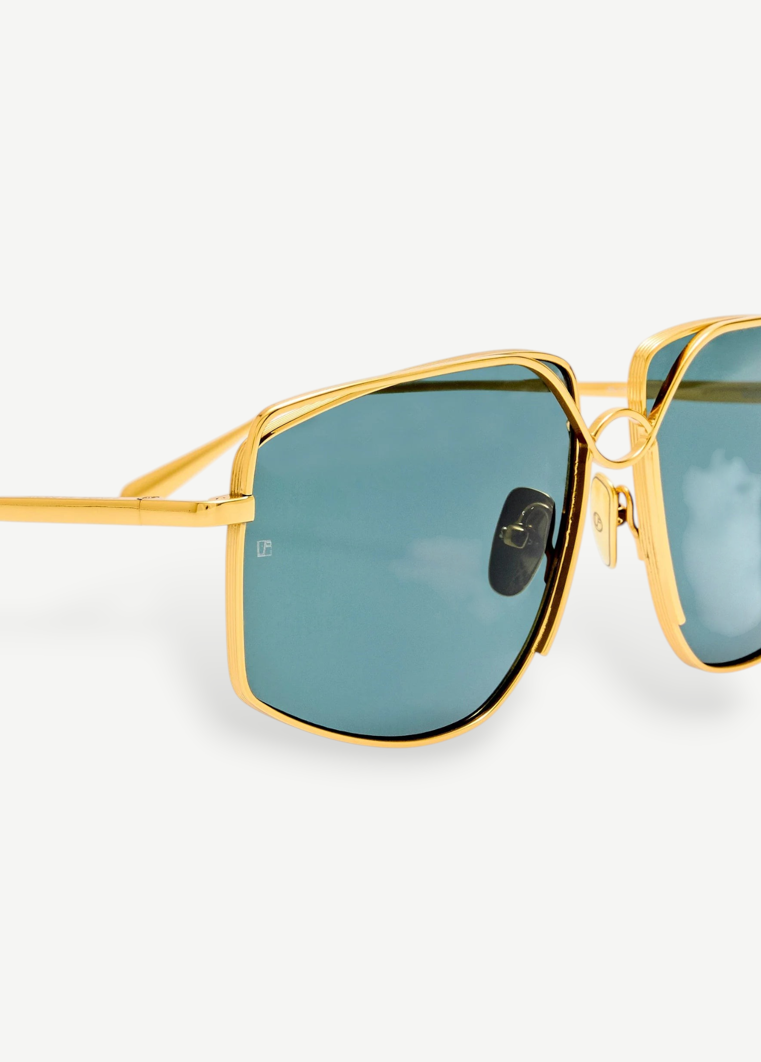 Close-up of the Miranda Sunglasses, featuring an oversized frame with gold-plated metal accents and green-tinted square lenses, shown against a plain white background.