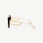 Side view of the Macy Sunglasses with gold geometric temples and black oversized frames, featuring aqua gradient lenses, displayed on a plain white background.